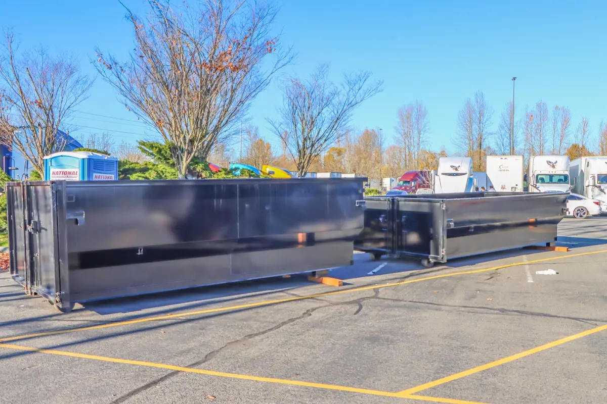 Professional dumpster rental service with roll-off container on residential driveway in Webster City